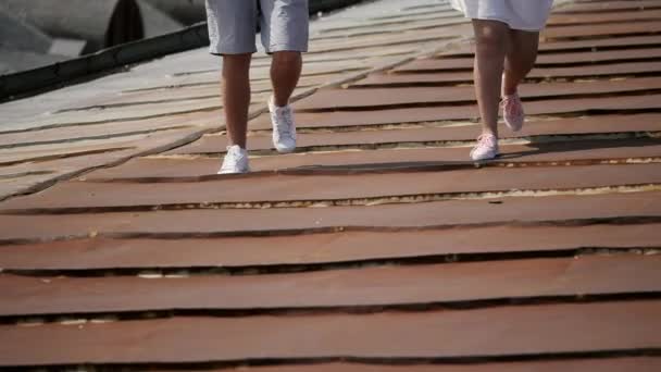 Ноги мужчины и женщины, идущие по крыше — стоковое видео