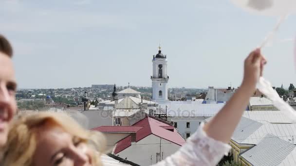 Para trzymając kilka balonów na rooftoop. Szczelnie-do góry. — Wideo stockowe