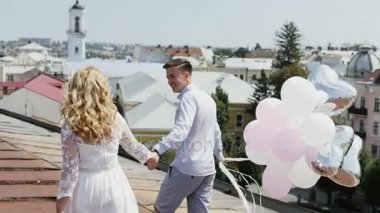 Bazı ballons tutarak ve sonra hava balonları çatıda demet salıverme Çift