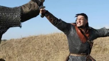 İki savaşçı Viking çayırda kılıç ile mücadele.