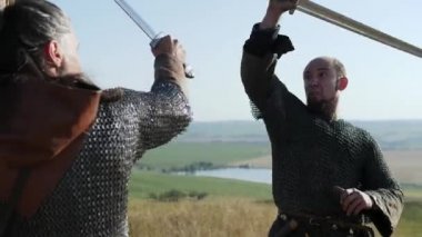İki savaşçı Viking çayırda kılıç ile mücadele.