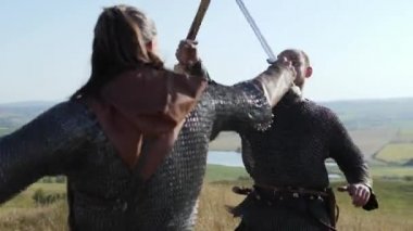 İki savaşçı Viking çayırda kılıç ile mücadele.