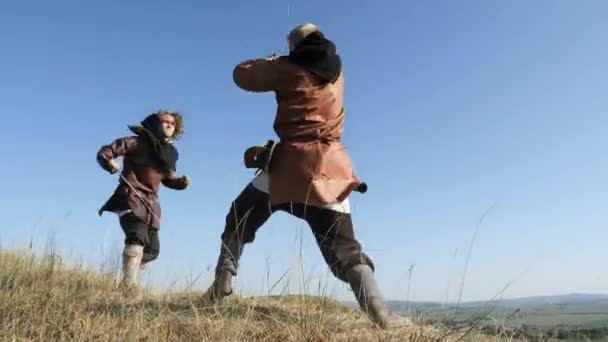 Два воина, викинги, сражаются мечами — стоковое видео
