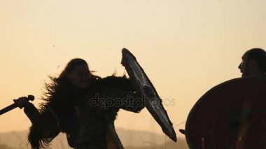 Savaşçı Viking siluetleri kılıç ve kalkanlar ile mücadele ediyoruz. Contre-jour