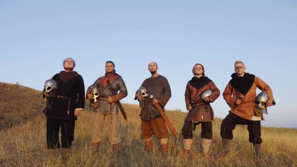 Портрет викингов, стоящих с мечами и шлемами в руках . — стоковое видео