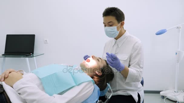 Стоматолог берёт пломбу для осмотра зубов . — стоковое видео