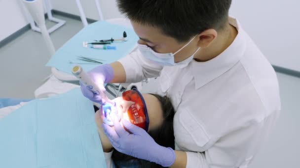 Γυναίκα να πάρει Uv λεύκανση στο γραφείο οδοντιάτρων από ένα ultra violet μηχάνημα. — Αρχείο Βίντεο