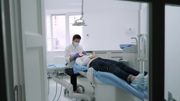 Zubař v práci view, kamera sledování ze zubní ordinaci do okna. — Stock video