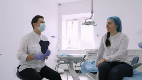 Tandläkaren ger till sin patient en spegel. — Stockvideo