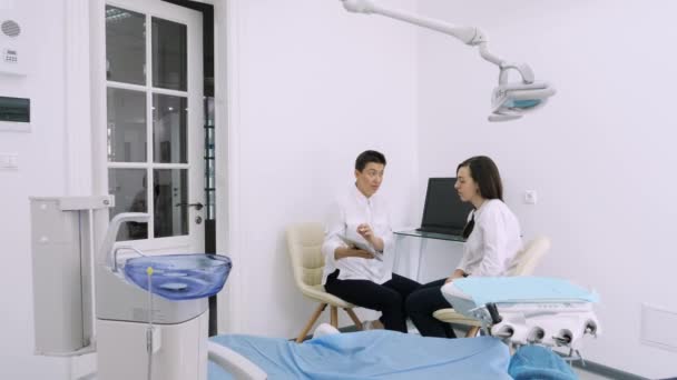 Dentista mostrando al cliente la radiografía de su tableta en el consultorio dental — Vídeos de Stock