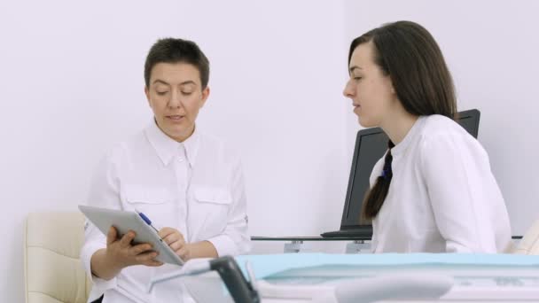 Zubař ukazuje klient x-ray na tabletu v zubní ordinaci — Stock video