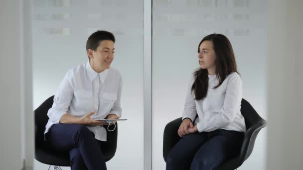 Tandarts in gesprek met jonge vrouwelijke patiënt in bij de tandarts kliniek. — Stockvideo