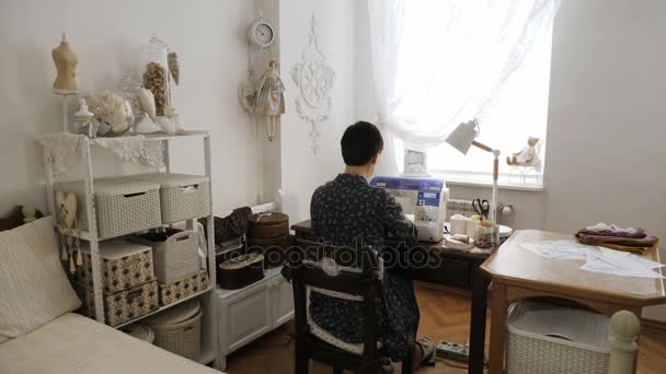 La mujer está trabajando en la máquina de coser. Vista trasera . — Vídeos de Stock