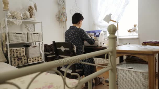Žena pracuje na šicí stroj. Pohled zezadu. — Stock video