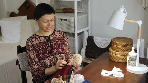 Eine Frau kleidet eine Puppe in Kleider. — Stockvideo