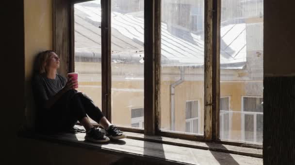 Young girl with coffee sits in a depression — Stock Video