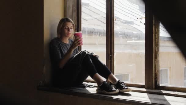 Chica joven con café se sienta en una depresión — Vídeos de Stock