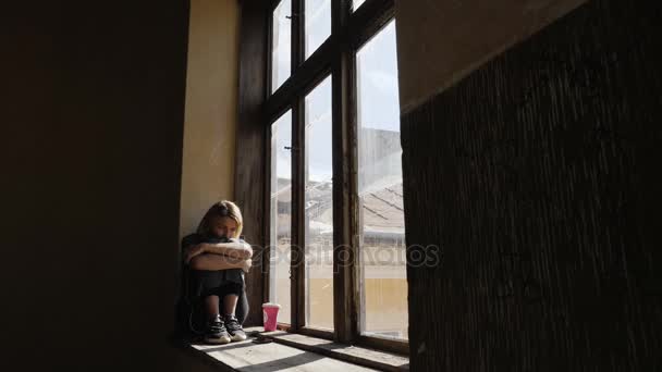 Κορίτσι φαίνεται πολύ λυπημένος, ενώ ακούτε μουσική στα ακουστικά από το παράθυρο — Αρχείο Βίντεο