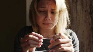 Pencere pozitif gebelik testi sonucu hakkında oturup ağlayan kadın