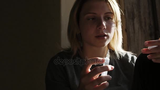 Depressief gezicht van een meisje dat denkt aan een spuit met heroïne — Stockvideo