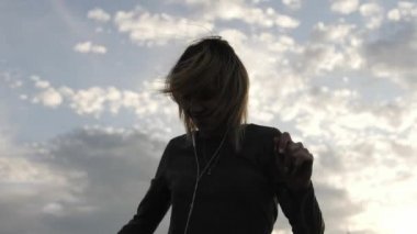 Çatı katında dans kulaklık, müzik dinleme sırasında mutlu hissediyor kadın.