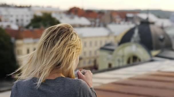 Mujer borracha bebe alcohol en la azotea.Viento soplando su cabello . — Vídeos de Stock