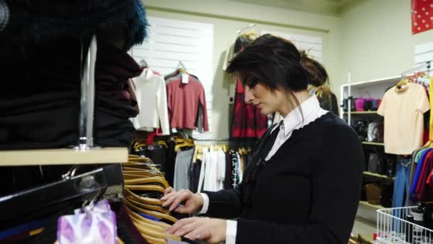 Piękna kobieta wybrać ubrania w sklepie — Wideo stockowe