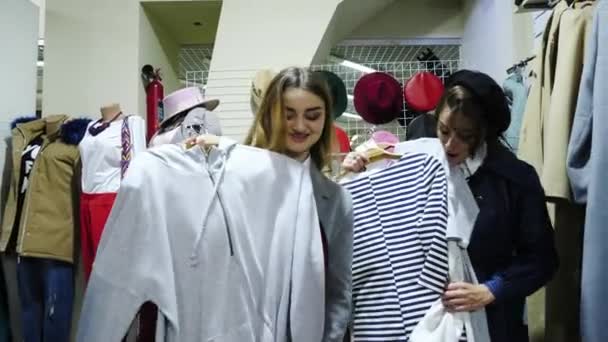 Две веселые молодые женщины выбрали одежду и очень счастливы — стоковое видео