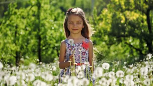 Portrait d'une fille dans le jardin avec des pissenlits. Mouvement lent . — Video