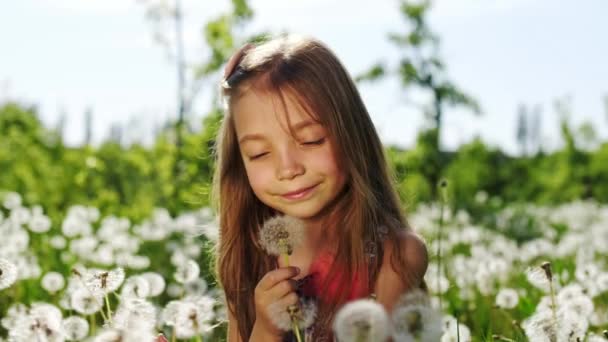 Retrato de una niña en el jardín con dientes de león. Movimiento lento . — Vídeos de Stock