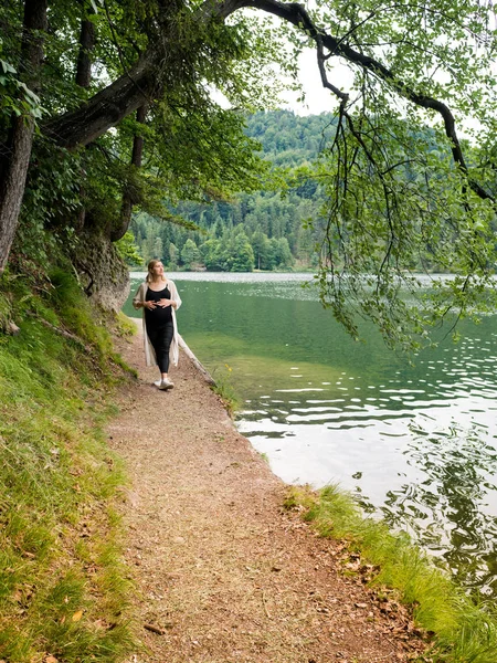 Όμορφη έγκυος γυναίκα κοντά σε μια λίμνη στο δάσος. — Φωτογραφία Αρχείου