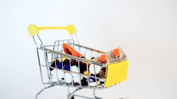 Carrello del supermercato pieno di capsule mediche su sfondo bianco — Video Stock