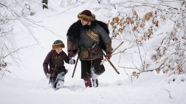 冬の森に行く彼の息子と一緒にバイキングの父. — ストック写真