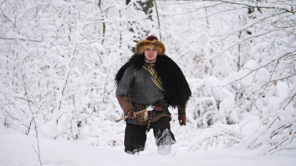 Man viking going in the winter forest.