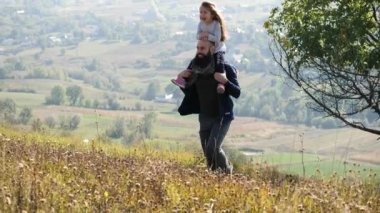 Mutlu baba ve küçük daghter sonbahar çayırlarında yürüyor ve eğleniyorlar..