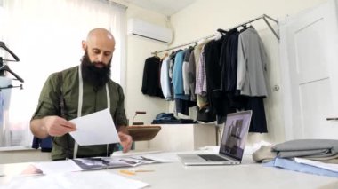 Terzi atölyesinde eskizlerle çalışıyor..