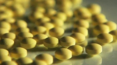 Cam masaya saçılmış sarı haplar.