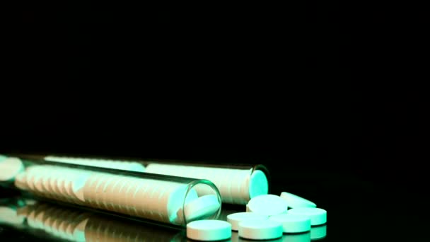 Generické léky na stole, kamera se pohybuje pomalu přes rozlité pilulky a do láhve. — Stock video