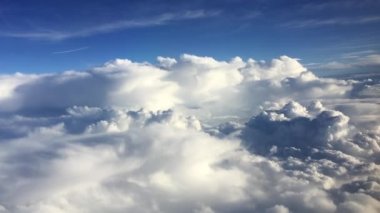 Bulutların üstündeki hava görüntüsü inanılmaz. Bulutların üzerinde uçuyor. Uçak penceresinden mavi gökyüzüne ve beyaz bulutlara bak. Uçaktan hava görüntüsü.