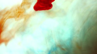 Alttan renkli gökkuşağı boyası damlıyor ve suya karışıyor. Yakın plan..