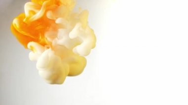 Alttan renkli gökkuşağı boyası damlıyor ve suya karışıyor. Yakın plan..