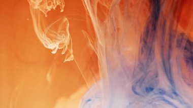 Alttan renkli gökkuşağı boyası damlıyor ve suya karışıyor. Yakın plan..