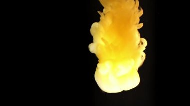 Alttan renkli gökkuşağı boyası damlıyor ve suya karışıyor. Yakın plan..