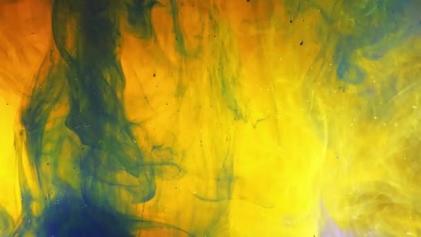 Barevná duhová barva kapky ze dna míchání ve vodě. Detailní záběr. — Stock video