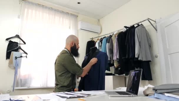 The tailor works with the lapel of the jacket on the dummy — Stock Video