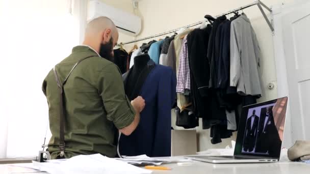 The tailor works with the lapel of the jacket on the dummy — Stock Video