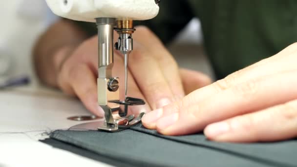 Primer plano de las manos de los sastres cosiendo en la máquina de coser . — Vídeos de Stock