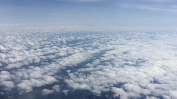Verbazingwekkende beelden van de lucht boven de wolken. Over de wolken vliegen. Zicht vanuit het vliegtuigraam op de blauwe lucht en witte wolken. Luchtzicht vanuit het vliegtuig. — Stockvideo