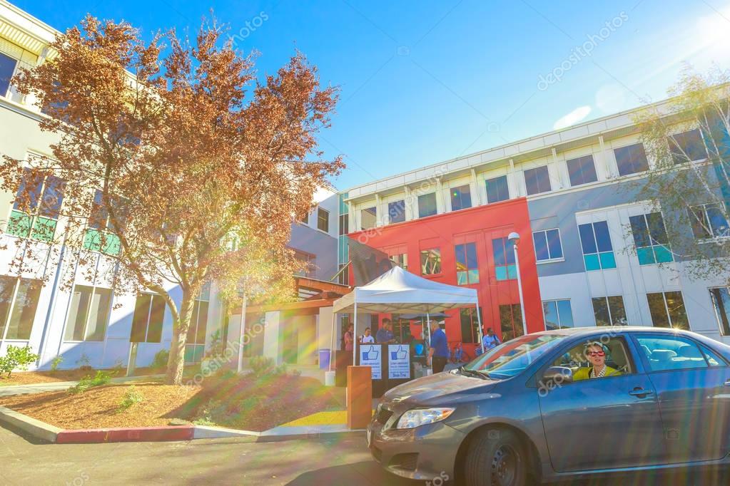 Mountain View, CA, United States - August 15, 2016: vallet parking lot with keepers at the entrance of Facebook headquarter, the world leader social network company. Typical LIKE logo signboards.