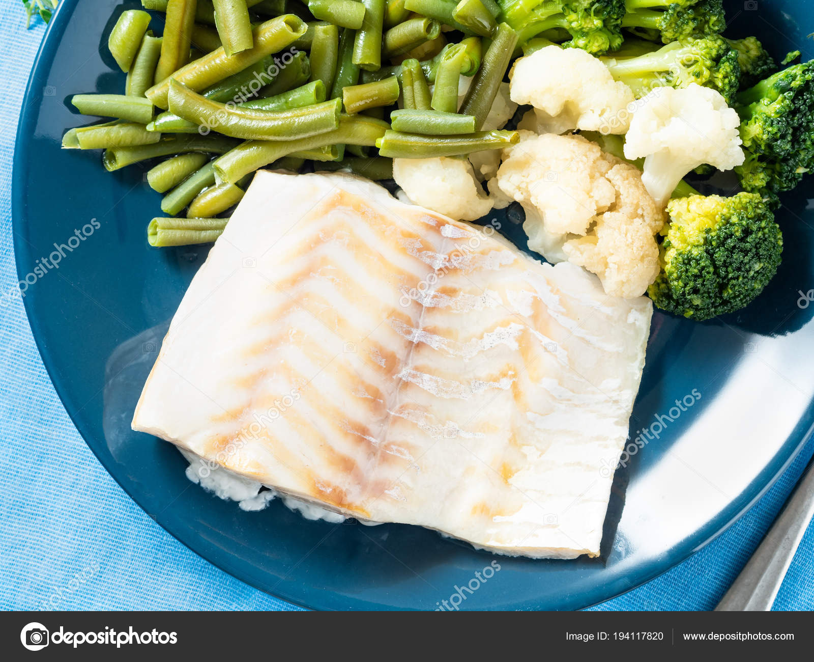 Gedunstetes Kabeljaufilet Mit Gemuse Auf Blauem Teller Oben Stockfoto C Natabene